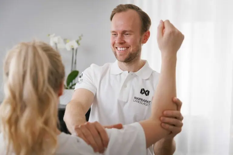Manlig naprapat behandlar skuldra, arm, axel