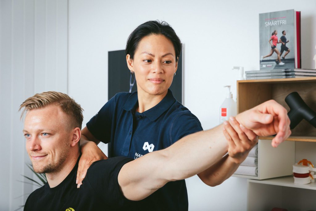 Naprapat som utfører behandling på en pasient sin arm